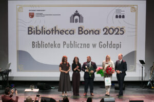 Prezentacja na scenie laureatki tytułu Bibliotheca Bona 2025. Od lewej: Adrianna Walendziak – Dyrektorka WBP w Olsztynie, Joanna Kaska – Zastępca Dyrektorki WBP w Olsztynie, Damian Czarniewski – Zastępca Burmistrza Gołdapi, Agnieszka Dziobkowska – Dyrektorka BP w Gołdapi, Marcin Kuchciński – Marszałek Województwa Warmińsko-Mazurskiego.